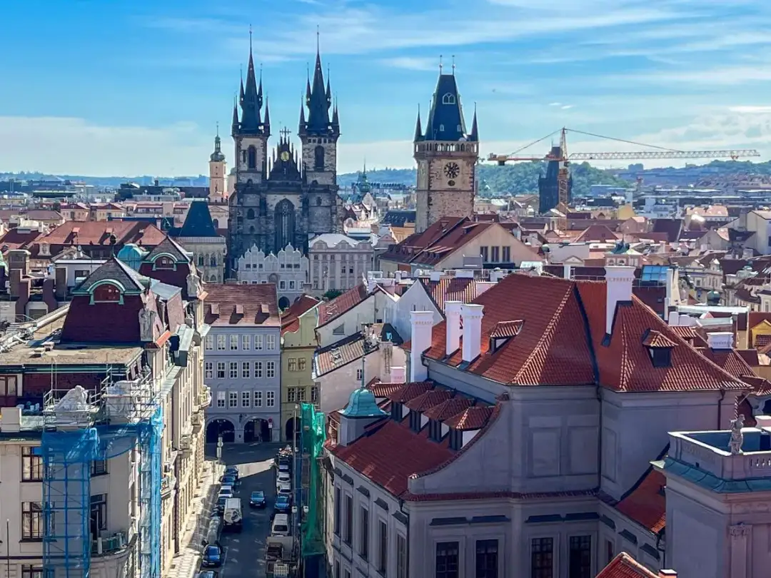 Widok na zabytkowe centrum Pragi, z dominującymi wieżami kościoła Marii Panny przed Tynem i Ratuszem Staromiejskim. W tle widać fragmenty biblioteki miejskiej w Pradze.