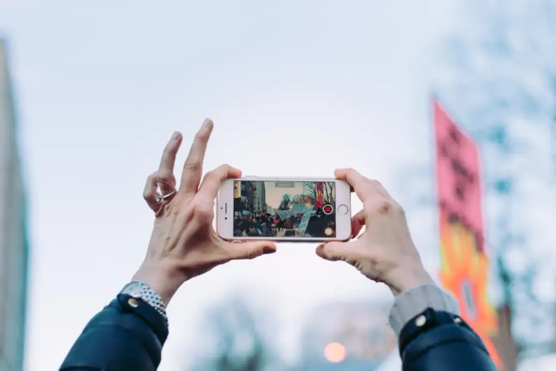 Obrót ekranu iPhone'a uchwycił protestujących z transparentami.