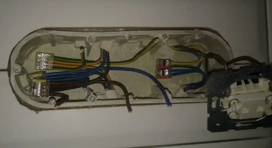 Instalacja elektryczna: jak podłączyć kable do wtyczki. Widoczne przewody w puszkach instalacyjnych, połączone złączkami.