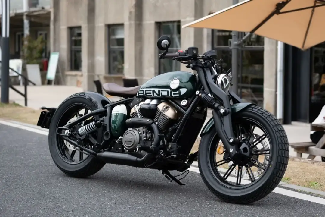 Stylowy, ciemnozielony motocykl Benda, wyglądający jak najmocniejszy motocykl 125, zaparkowany na ulicy.