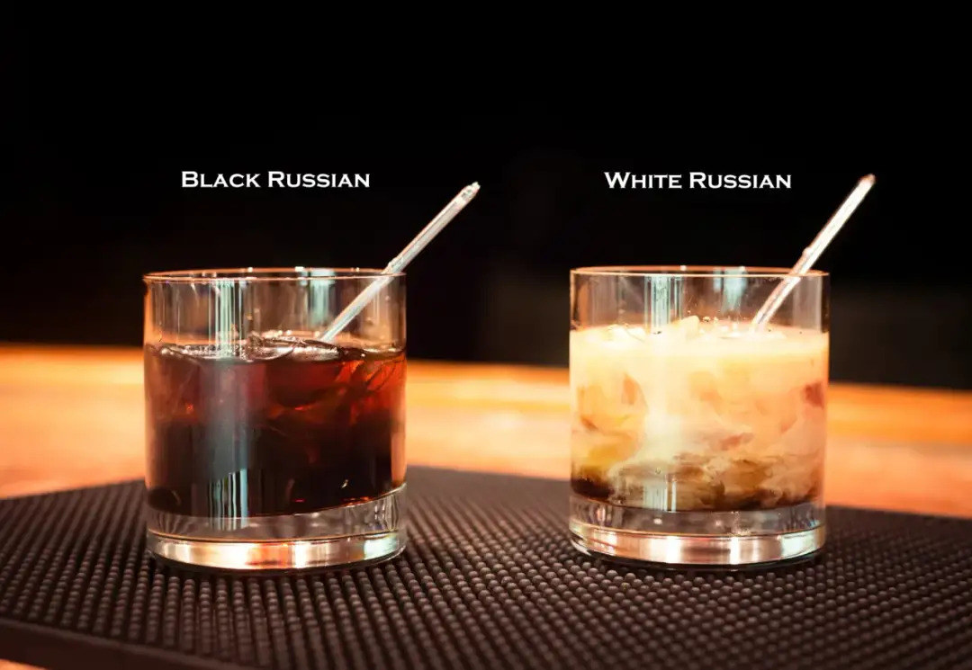 Dwa drinki: ciemny Black Russian z lodem i jasny White Russian z mlekiem, każdy w szklance z rurką.