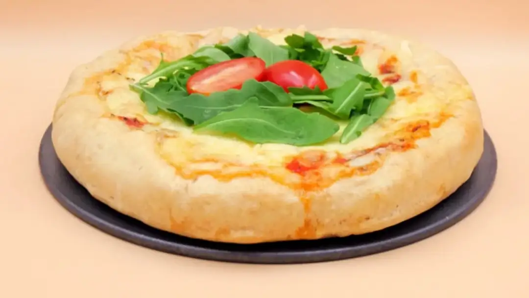 Puszyste brzegi pizzy, idealne do zrobienia, z rukolą i pomidorkami.