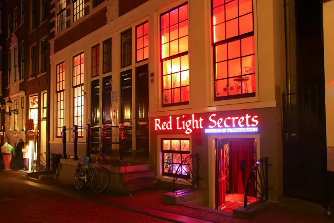 Neonowy szyld "Red Light Secrets Museum of Prostitution" nad wejściem do muzeum seksu w Amsterdamie.