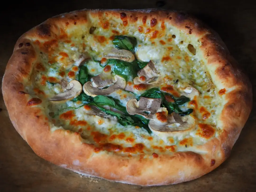Pyszna pizza z serem, szpinakiem i pieczarkami. Idealny pomysł na to, co dać na spód pizzy, gdy chcesz czegoś lekkiego i zdrowego.