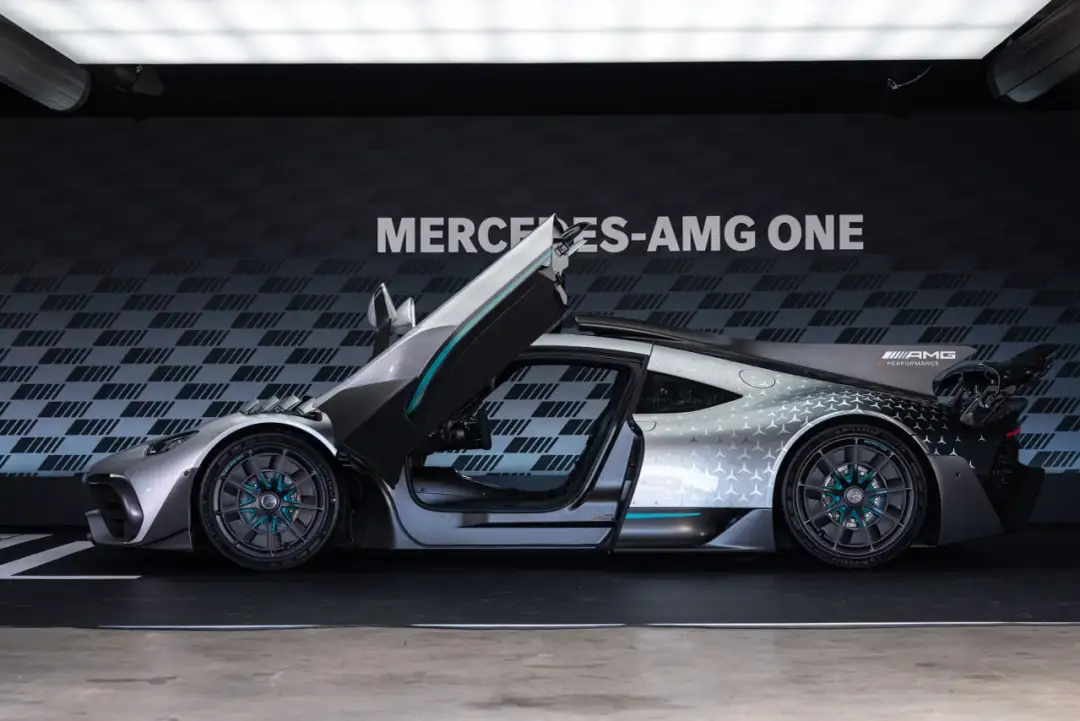 Srebrny Mercedes-AMG ONE z otwartymi drzwiami i maską, prezentujący swoje futurystyczne linie i sportowy charakter.