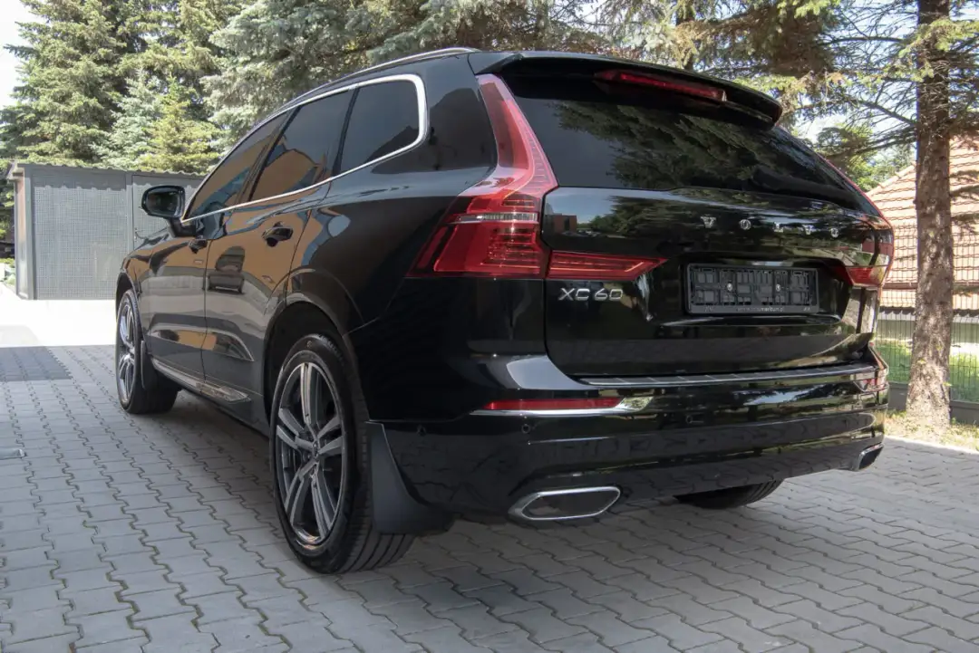 Czarne Volvo XC60 z zamontowanymi chlapaczami, gotowe na każdą drogę.