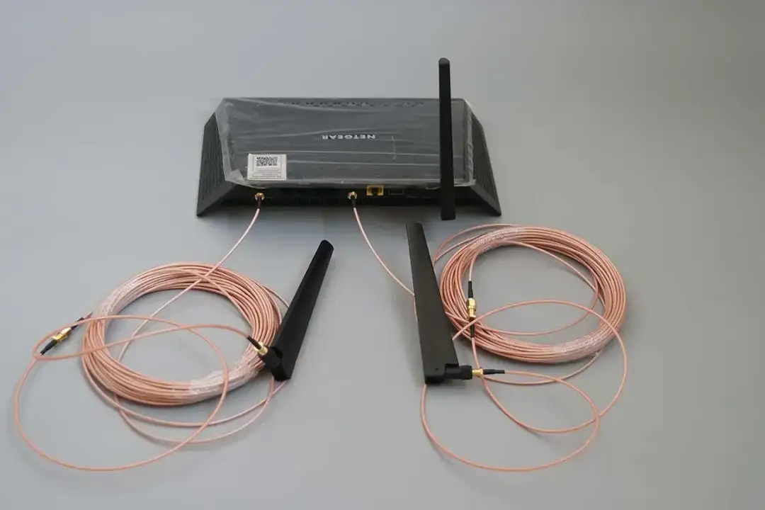 Router z dwoma kablami i antenami. Zastanawiasz się, czy można przedłużyć kabel antenowy? Tak, zestawy jak ten pozwalają na to.