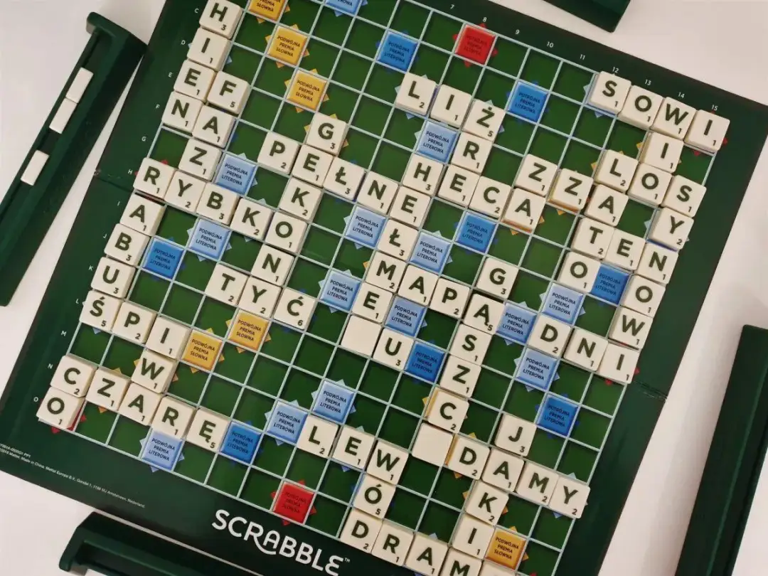 Plansza do gry Scrabble z ułożonymi polskimi słowami i literami.