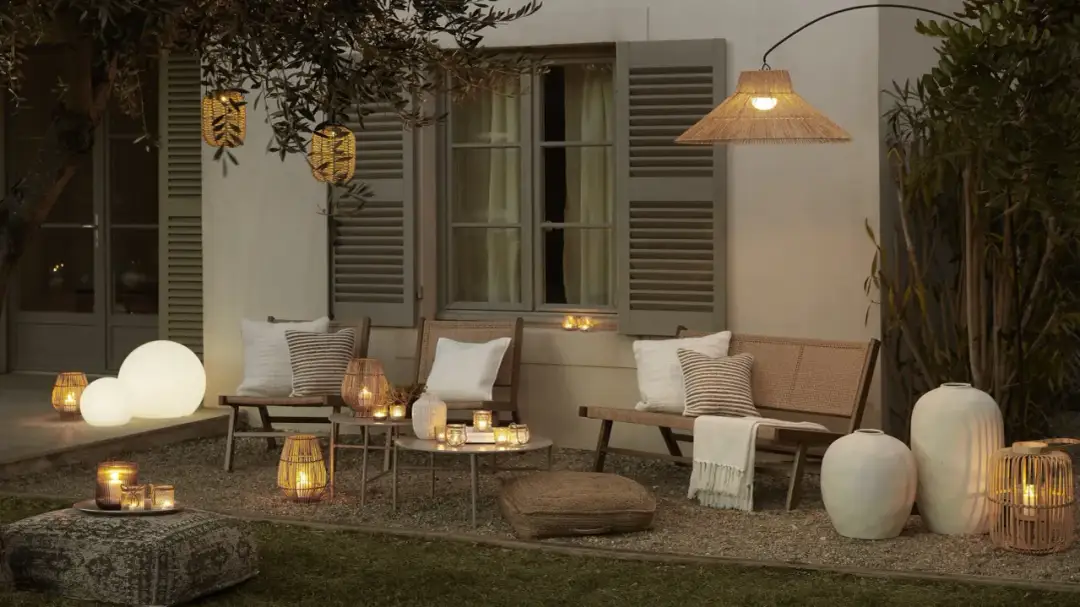 Przytulne oświetlenie na taras tworzy nastrojową atmosferę. Lampiony, kule świetlne i wisząca lampa z plecionki dodają ciepła.