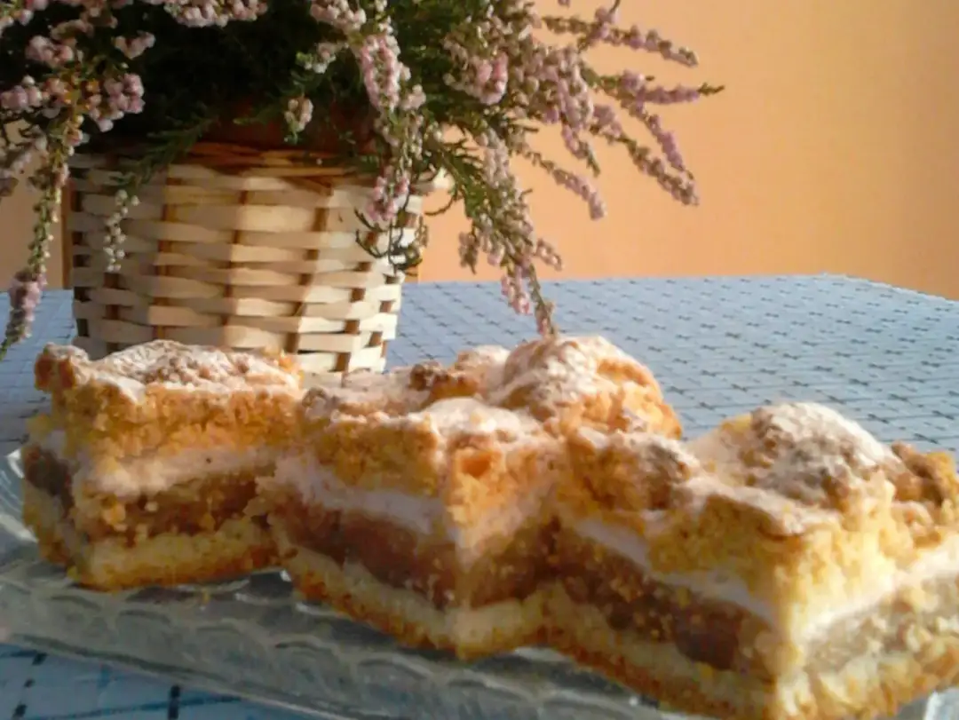 Pyszna szarlotka na talerzu, która nie opadła! Idealna na deser, z koszykiem wrzosów w tle.