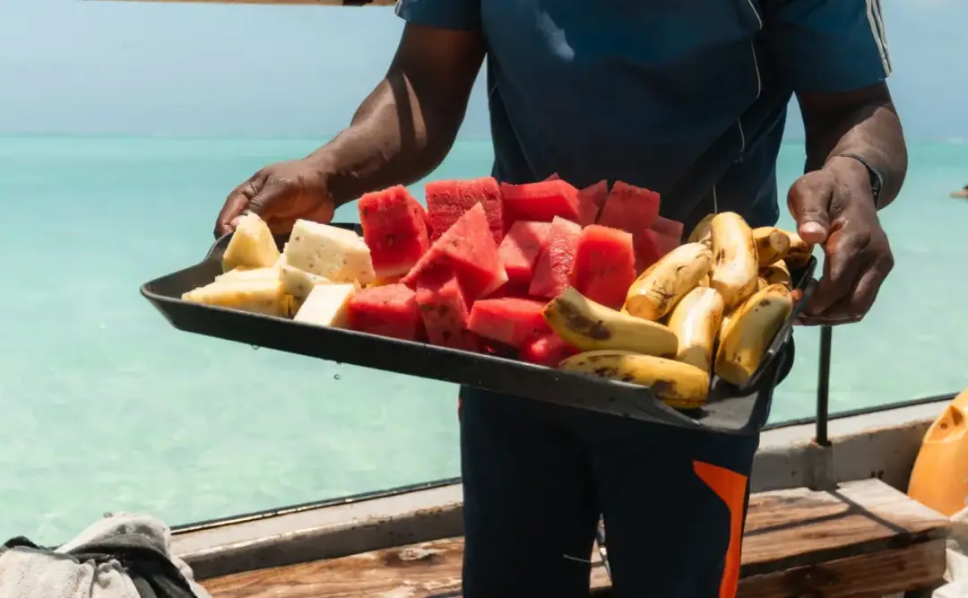 Talerz z arbuzem, ananasem i bananami na łodzi. Zastanawiasz się, ile kosztuje obiad na Zanzibarze?