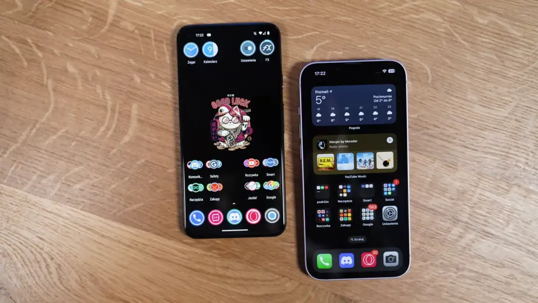 Dwa smartfony, jeden z Androidem, drugi z iOS, leżące na drewnianym blacie.