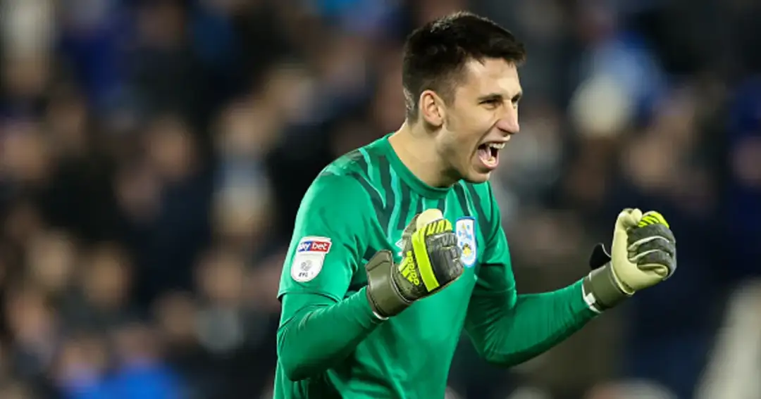 Bramkarz Kamil Grabara w zielonej koszulce, cieszący się ze zwycięstwa, zaciśnięte pięści.