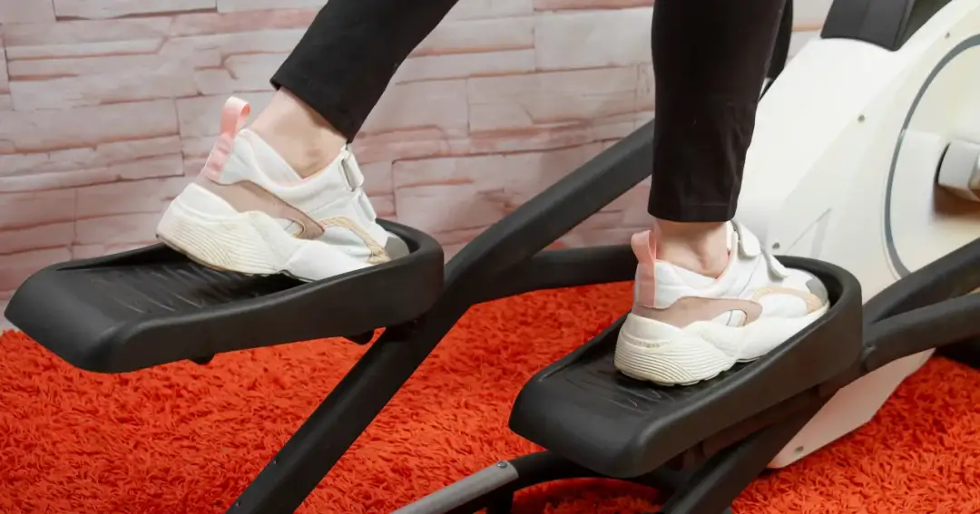 Osoba ćwiczy na orbitreku, który jest dobrym wyborem dla kręgosłupa.