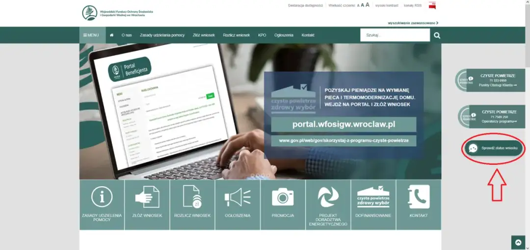 Ręce piszące na laptopie, na ekranie którego widać portal beneficjenta i przycisk "Sprawdź status wniosku".