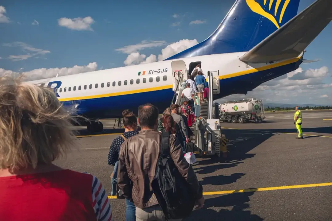Pasażerowie wsiadają po schodkach do samolotu Ryanair.