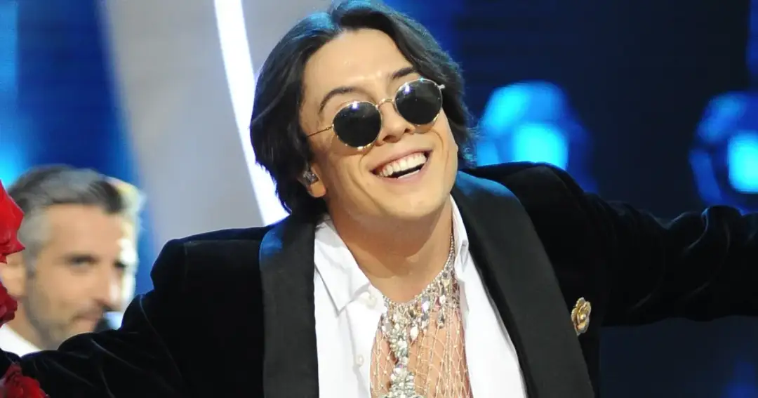 Uśmiechnięty Dawid Kwiatkowski w okularach i błyszczącym naszyjniku. Fani zastanawiają się, czy Dawid Kwiatkowski jest żonaty.