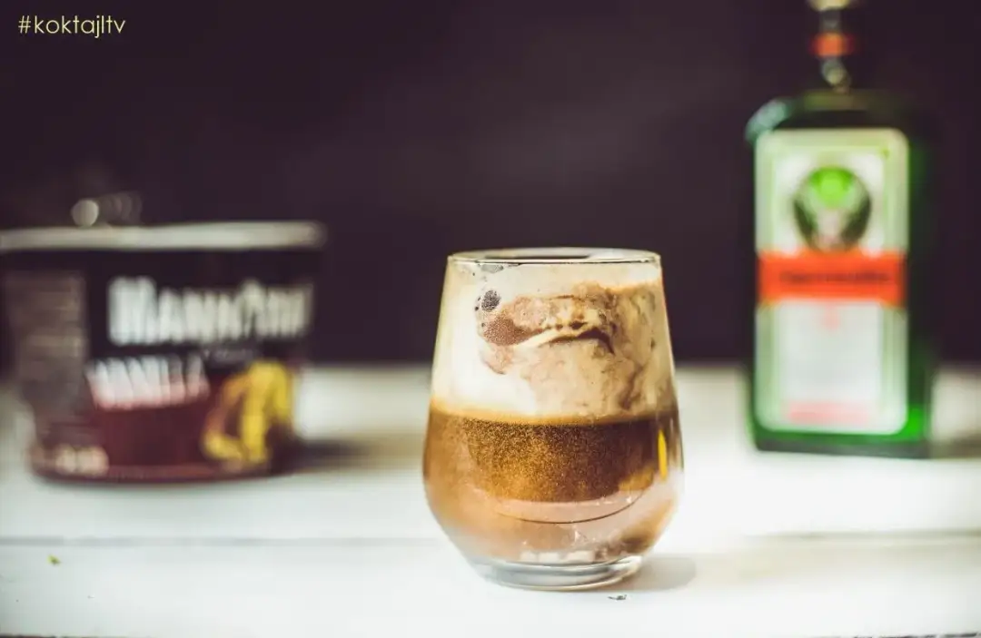 Pyszne drinki z jagera z lodami waniliowymi i pianką. Obok butelka Jägermeistera i puszka lodów.