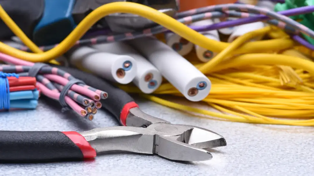 Narzędzia i kable elektryczne, gotowe do podłączenia prądu do działki.