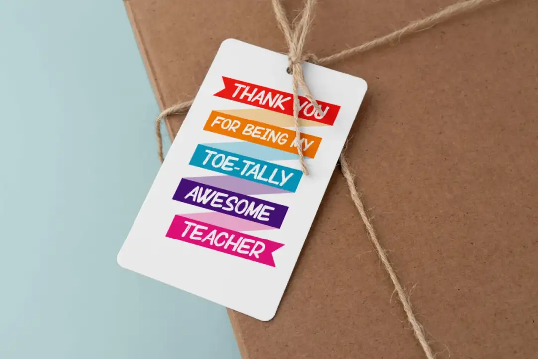 Uroczy prezent na dzień nauczyciela z kolorową etykietą: "Dziękuję za bycie NIESAMOWITYM nauczycielem".