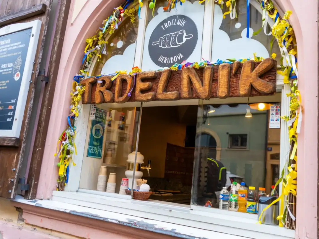 Na szyldzie stoiska z Trdelníkiem widać napisy w języku czeskim, a ceny podane są w koronach czeskich (Kč).