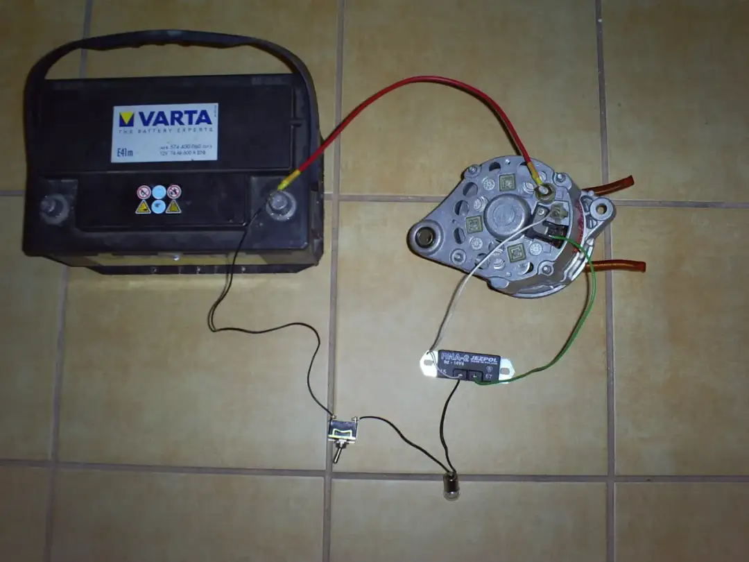 Akumulator Varta, alternator, regulator napięcia i żarówka połączone przewodami.