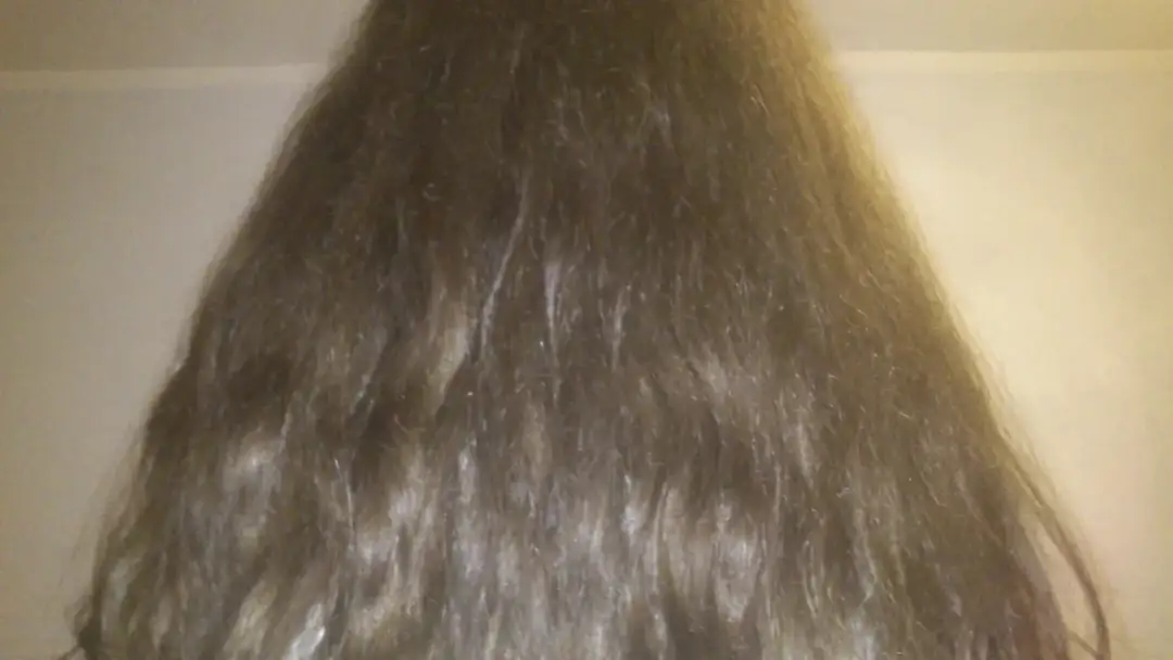 Długie, brązowe włosy z falami, które mogą być podatne na puszenie. Idealne do wypróbowania różnych fryzur dla włosów falowanych puszących się.