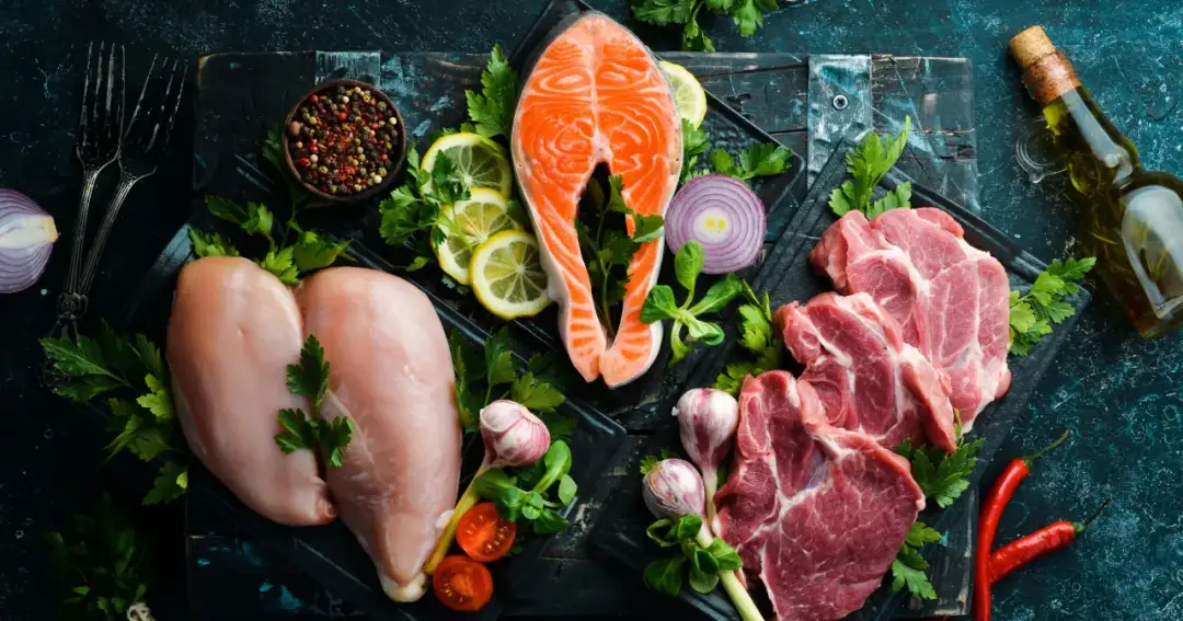 Łosoś, kurczak i wieprzowina na desce. Zastanawiasz się, jakie mięso jest najzdrowsze? Wybór zależy od potrzeb.
