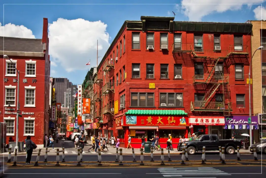 Tętniąca życiem ulica w 13 dzielnicy Paryża, pełna czerwonych budynków, azjatyckich szyldów i ludzi.