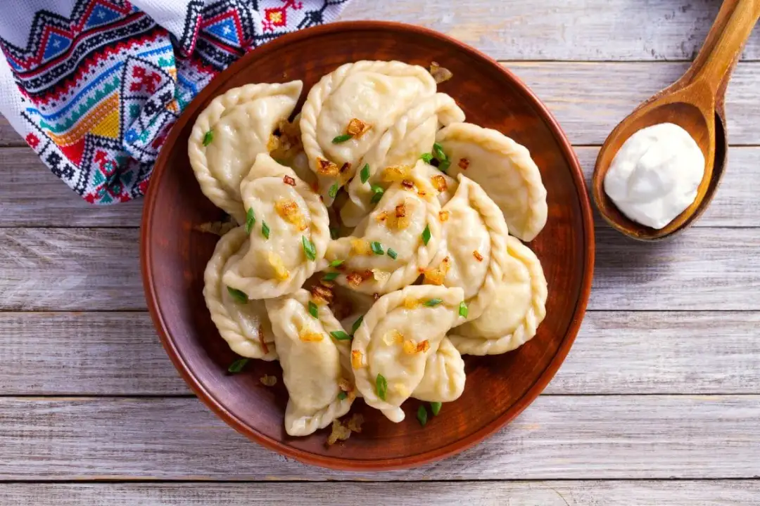 Talerz pysznych, domowych pierogów z cebulką i szczypiorkiem. Zastanawiasz się, ile wyjdzie pierogów z pół kilograma mąki? Tyle pyszności!