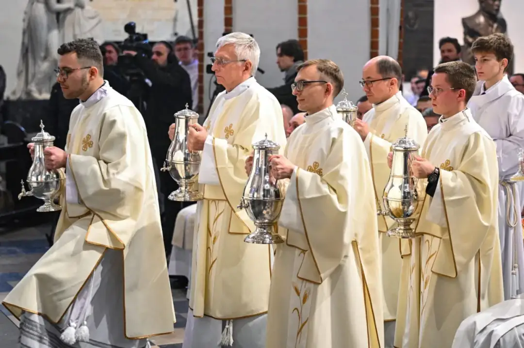 Księża niosą srebrne ampułki podczas mszy w Wielki Czwartek.
