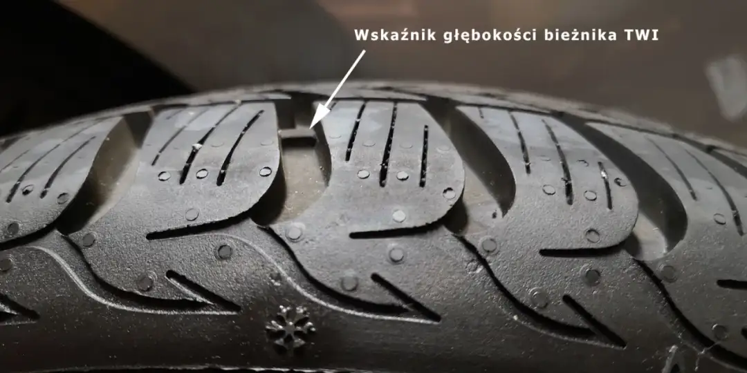 Zbliżenie na bieżnik opony zimowej z widocznym wskaźnikiem TWI.