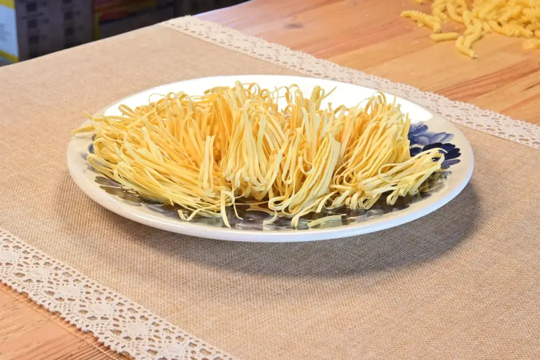 Talerz pełen świeżego makaronu tagliatelle, idealna porcja na osobę.