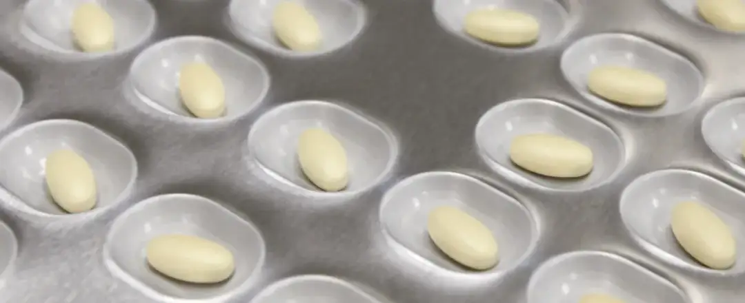 Blister opakowanie z żółtawymi tabletkami.