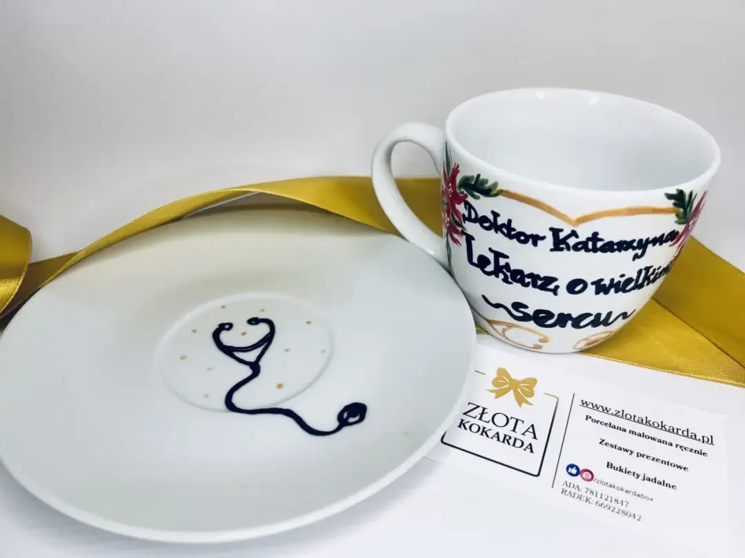 Biała filiżanka i spodek z motywem stetoskopu i napisem "Doktor Katarzyna".