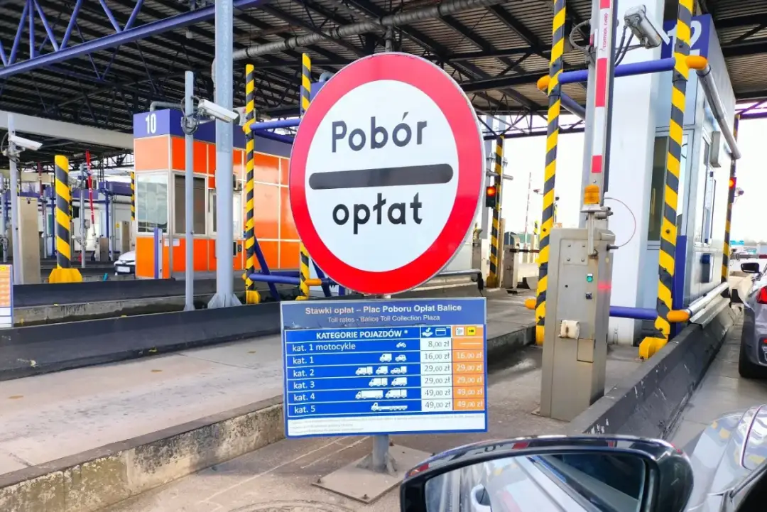 Znak drogowy "Pobór opłat" na placu poboru opłat Balice z tabelą stawek.