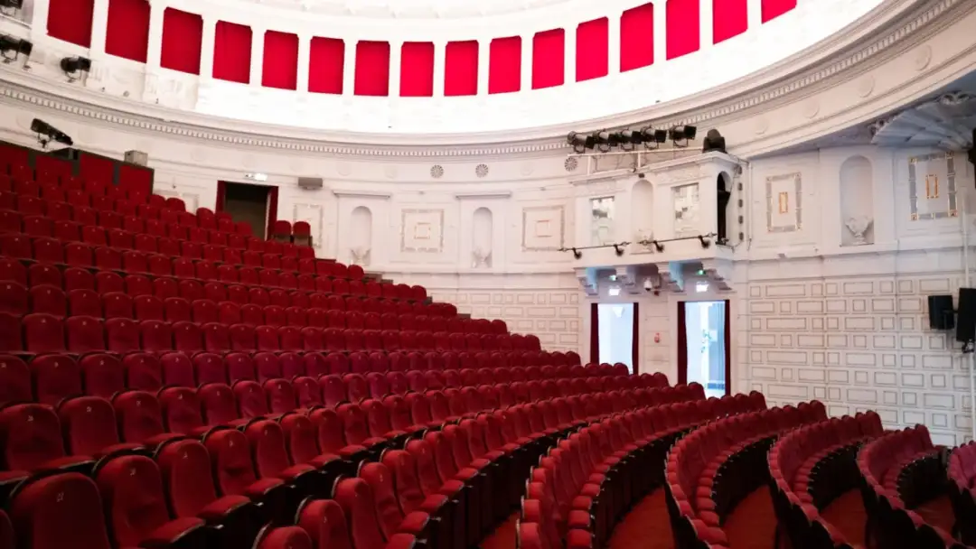 Puste czerwone fotele w teatrze Komedia w Warszawie. Czekają na widzów, by obejrzeć repertuar.