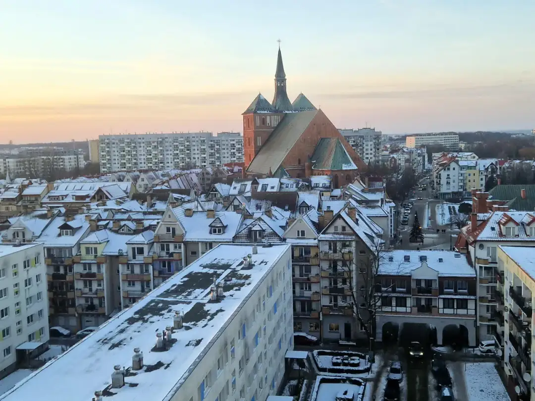 Zimowy krajobraz Kołobrzegu z ośnieżonymi dachami i katedrą. Miasto liczy ok. 45 tys. mieszkańców.