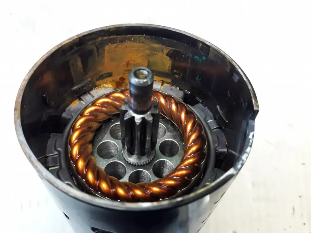 Wnętrze silnika z widocznym uzwojeniem i zębatką. Dowiedz się, jak sprawdzić czujnik położenia wału.