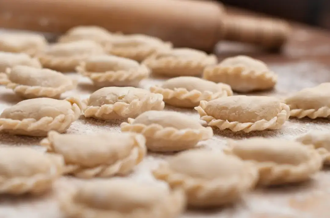 Mnóstwo surowych pierogów czeka na gotowanie. Zastanawiasz się, ile wychodzi pierogów z kilograma mąki?