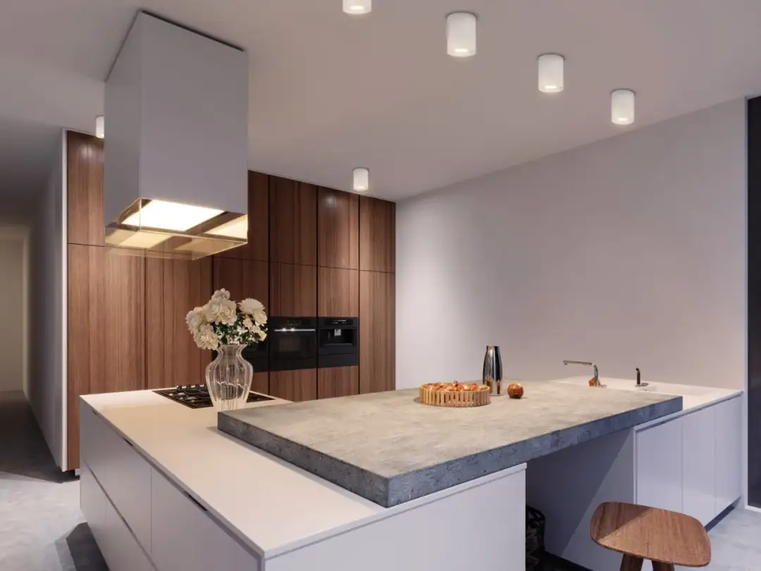 Nowoczesna kuchnia z wyspą, betonowym blatem i białymi lampami tubami na suficie.