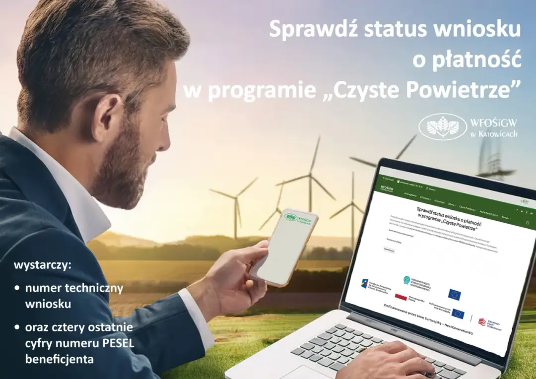 Mężczyzna sprawdza status wniosku na laptopie i telefonie, na tle farmy wiatrowej.