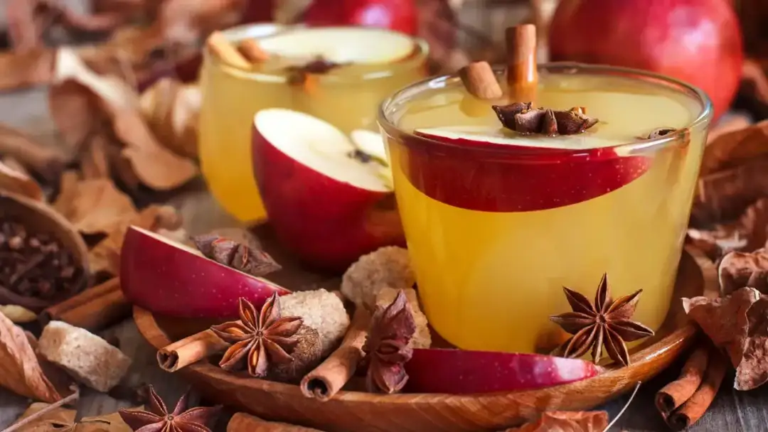 Ciepłe, aromatyczne grzane białe wino z jabłkami, cynamonem i anyżem, otulone jesiennymi liśćmi.