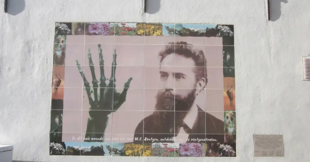W.C. Röntgen, kto odkrył promienie X, na muralu z jego portretem i zdjęciem dłoni.