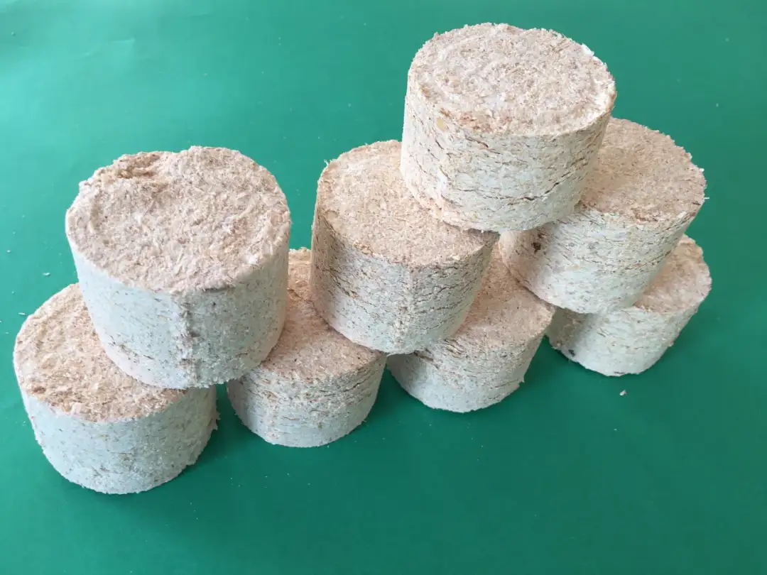 Stos trocinowych brykietów, które można zrobić domowym sposobem. Idealne do palenia.