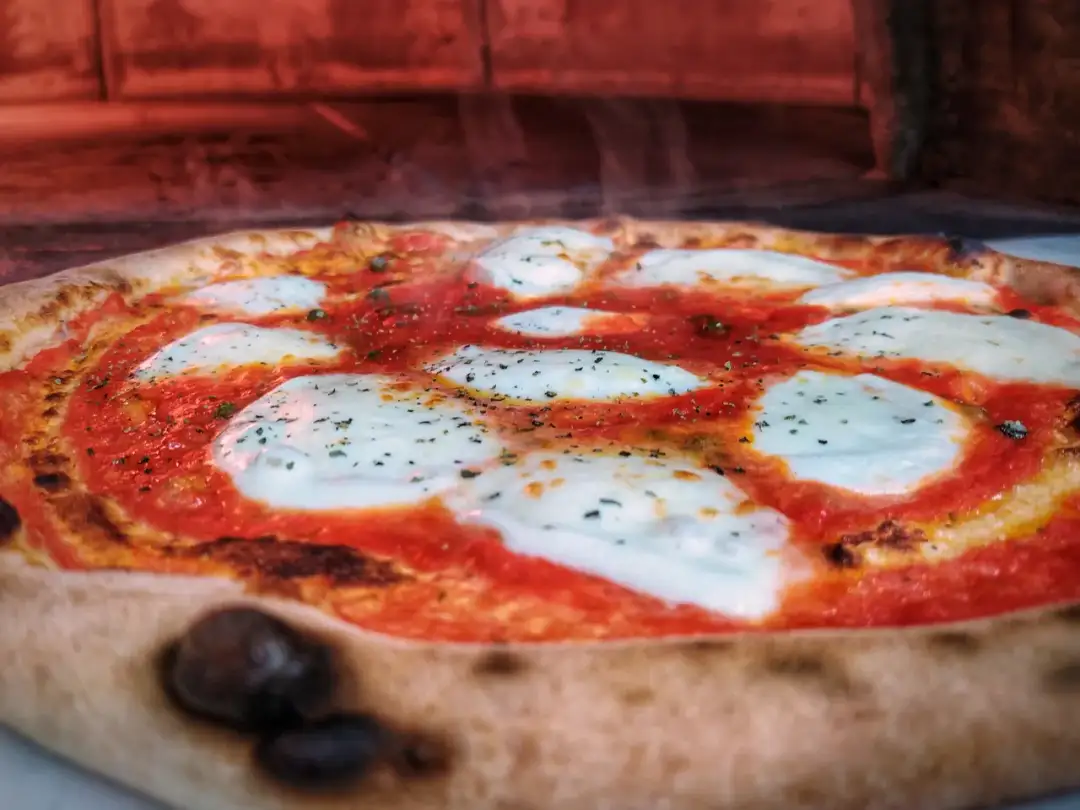 Gorąca pizza z ciągnącym serem i sosem pomidorowym. Czy pizza jest lekkostrawna? Ta wygląda apetycznie!