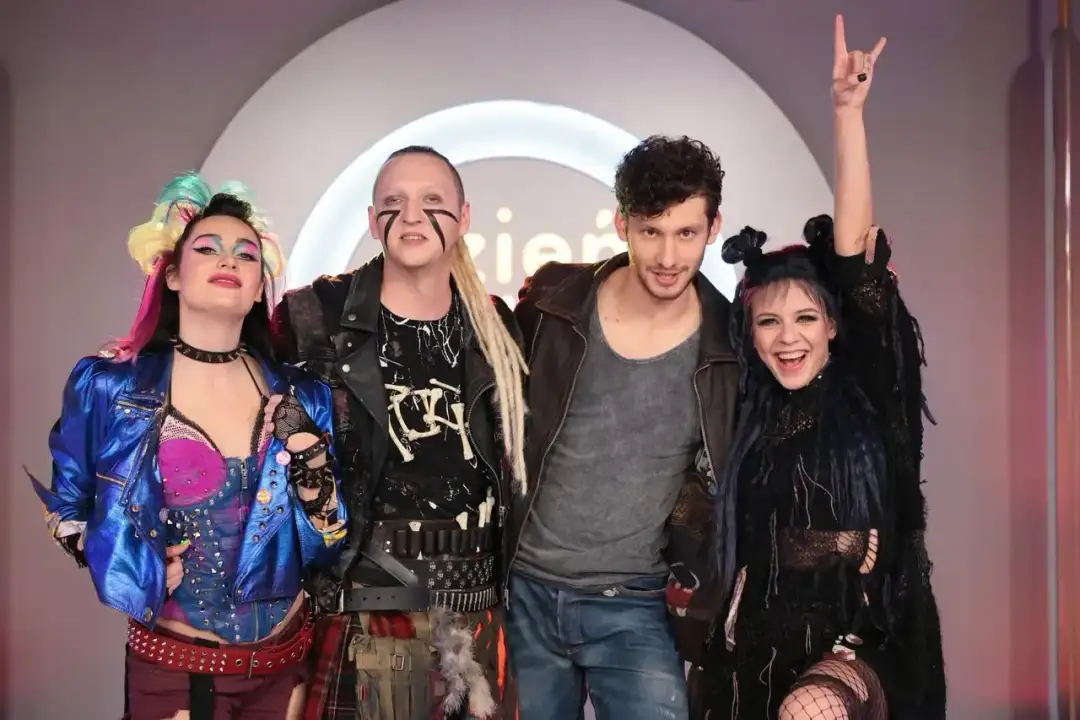 Cztery osoby w rockowych strojach, w tym jedna z podniesioną ręką w geście rock'n'rolla. To z pewnością ekipa z "We Will Rock You Roma Obsada"!