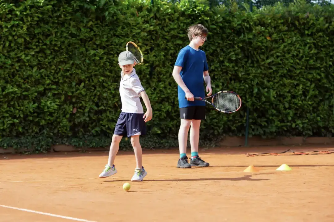 dzieci na korcie tenisowym przed treningiem