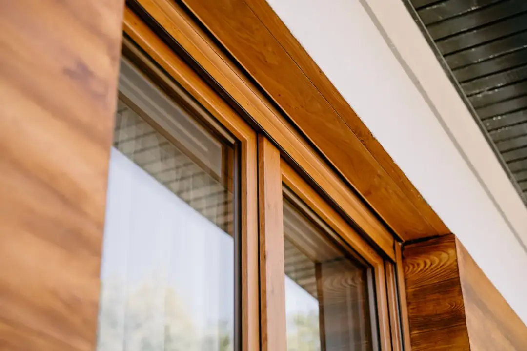 Drewniane okna trzyszybowe, choć estetyczne, mogą mieć wady. Widoczny detal ramy okiennej.