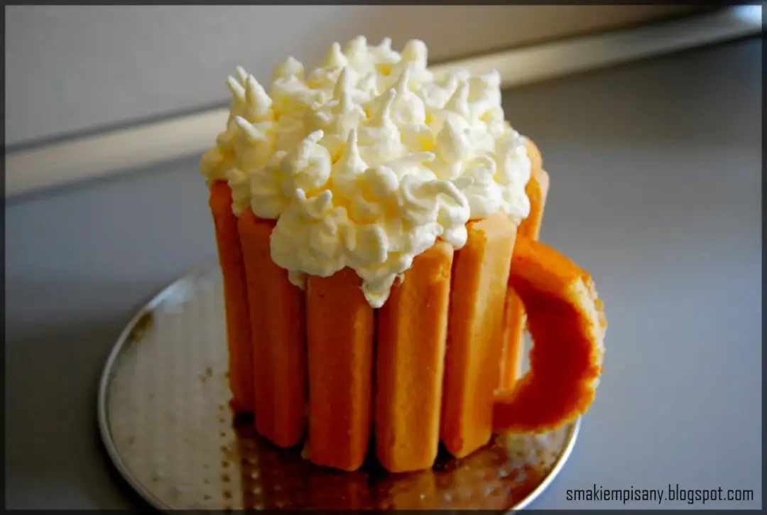 Tort w kształcie kufla piwa z bitą śmietaną.